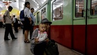 Seorang kakek memeluk cucunya sambil melihat kereta perlahan meninggalkan stasiun bawah tanah di Pyongyang. Reuters/Danish Siddiqui.