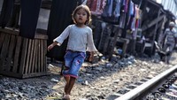 Seorang anak beraktivitas di pinggir rel yang berbahaya bagi dirinya.