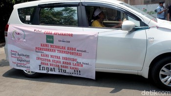 Mobil-mobil para peserta aksi demo terparkir di badan jalan memakan dua lajur. Akibatnya, lalu lintas menjadi tersendat. Sejumlah personel Polisi Lalu Lintas tampak melakukan pengaturan di lokasi.