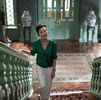 Michelle Yeoh bermain sebagai Eleanor, ibu Nick yang berasal dari keluarga kaya. Ia pun banyak menggunakan busana keluaran desainer kenamaan. Kali ini, Eleanor memakai blus wrap hijau emerald Diane Von Furstenberg. Gaya Eleanor sengaja dibuat kontras dan kuat di banding Rachel untuk menunjukkan perseteruan dan intimidasi. Foto: Warner Bros