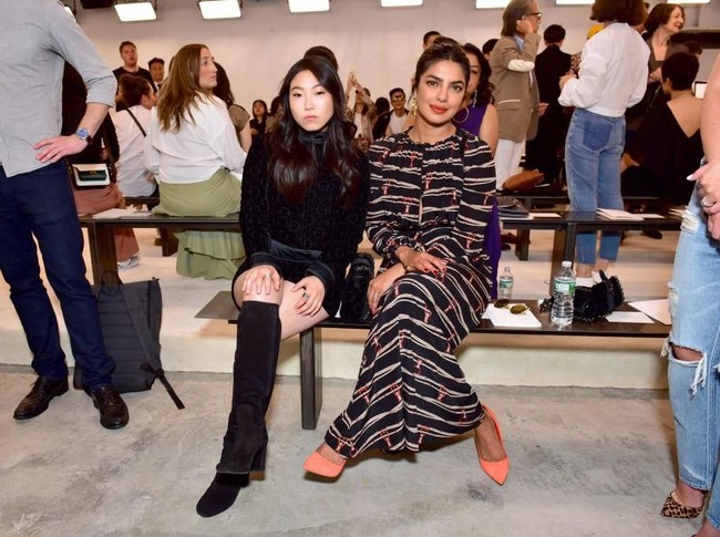 Awkwafina, yang berperan sebagai Peik Lin Goh, berpose bersama Priyanka Chopra di fashion show Longchamp. (Foto: Getty Images)