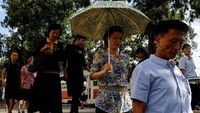 Para penumpang memasuki stasiun bawah tanah di Pyongyang. Nampak seorang penumpang perempuan memakai payung. Reuters/Danish Siddiqui.