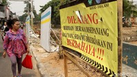 Sesekali warga melintas dan berhenti sejenak untuk melihat proses pemasangan turap di Kali Krendang.