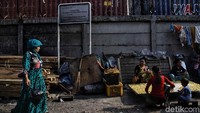 Seorang warga melintas di depan plang larangan mendirikan bangunan di sepanjang rel kereta api.