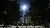 Warga Amerika tampak menyaksikan dan mengabadikan momen festival lampu dalam penghormatan tragedi 11 September di Kota New York. Andrew Kelly/Reuters.