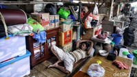Seorang warga terpaksa tidur diatas tumpukan karton dan barang-barang yang mereka selamatkan seperti ini.