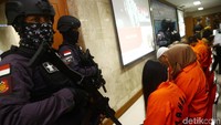 Para pelaku dihadirkan dengan penjagaan ketat polisi bersenjata lengkap.