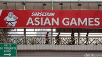 Warga melintasi JPO yang terdapat spanduk promosi Asian Games di kawasan Benhil, Jakarta Pusat.