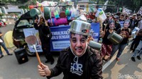 Dalam aksi itu, pendemo memakai topeng bergambar wajah Roy Suryo. Mereka juga membawa barang-barang perabotan rumah tangga.