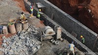 Sejumlah pekerja membangun saluran air di sepanjang tol.