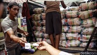 Petugas lainnya tampak memberikan karungan beras.