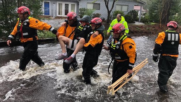 Petugas menolong seorang pria yang terkena banjir akibat badai Florence, Carolina Utara, AS, 14 September.