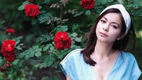Sandra Olga memperlihatkan kecantikannya dengan berpose berlatar belakang dedaunan hijauh berbunga merah. Foto: dok instagram