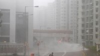 Seorang pria berjalan saat ombak tinggi menghantam pantai di Heng Fa Chuen, Hong Kong, sebuah distrik perumahan di dekat pantai. (Foto: Dok. REUTERS/Bobby Yip)