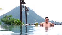 Santai berenang menikmati pemandangan gunung di belakang, Jordi melengkapinya sambil minum es kelapa. Wih, seger nih pasti! Foto: Instagram @jordionsu