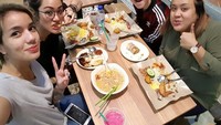 Nih, pas liburan ke Singapura. Sheila dan teman-temannya malah asyik makan nasi lemak yang dibungkus oleh kertas nasi. Foto: Instagram @itssheilamj