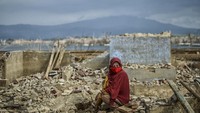 Tak hanya mencari ikan, Ibu Teti ini lebih memilih mengumpulkan batu bata dari puing bangunan untuk kemudian dipakai membuat pondasi kecil-kecilan di halaman rumahnya yang baru. Foto: AntaraFoto/Raisan Alfarisi
