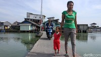Beberapa warga melintas di jalan setapak yang menghubungkan dengan kawasan di luar Kampung Apung.