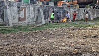 Meskipun banyak sampah berserakan dan aktivitas warga lainnya yang membakar sampah disana tak menyurutkan semangat anak-anak tersebut untuk bermain bola.