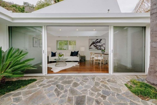 Ruangan khusus dilengkapi sofa dan meja makan yang berbatasan langsung dengan taman cantik dipenuhi tanaman hijau. Cocok untuk bersantai. Foto: Dok. Trulia, Dok. Sothebys International Realty