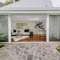 Ruangan khusus dilengkapi sofa dan meja makan yang berbatasan langsung dengan taman cantik dipenuhi tanaman hijau. Cocok untuk bersantai. Foto: Dok. Trulia, Dok. Sothebys International Realty