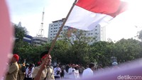 Sebagian peserta aksi mengibarkan bendera merah putih.