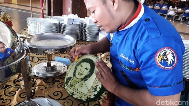 Mengukir wajah Menteri Susi di buah semangka. 