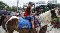 Senyum bahagia seorang anak menaiki kuda keliling kawasan Kemayoran.