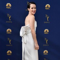 Pemeran Ratu Elizabeth II di serial The Crown, Claire Foy, tampil flawless dengan gaun muncul dengan gaun minimalis Calvin Klein yang dihiasi aksen pita bergaya struktural di belakangnya. (Foto: Getty Images)