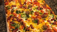 Pizza tak selalu berbentuk bulat, yang ini bentuknya persegi. Toppingnya berlimpahan mulai saus tomat, brokoli, paprika, bakso, salami, ayam dan tomat. Kejunya pakai kejo mozzarella dan cheddar. Foto : instagram @cherann3