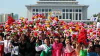 Sejumlah warga Korea Utara tampak antusias menyambut Pemimpin Korea Utara dan Presiden Korea Selatan saat melakukan iring-iringan di jalanan Pyongyang, Korea Utara. Tak hanya membawa bunga dan bendera Korea Utara, pertemuan kedua pemimpin negara ini dianggap sebagai momentum untuk Unifikasi Korea, sehingga ada pula warga yang mengibarkan bendera Korea. Pyeongyang Press Corps/Pool via Reuters.
