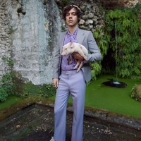 Kali ini giliran babi berwarna pink yang digendongnya. Harry sendiri terlihat stylish seperti biasanya dengan setelan jas bernuansa pastel. Ia mengenakan blouse pussy bow yang dipadu jas abu-abu dan celana violet, serta sneakers putih. Foto: Dok. Gucci