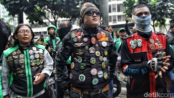 Para pengemudi ojek online berdatangan, lengkap dengan atribut seperti jaket dan bendera.