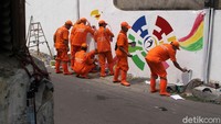 8 Anggota PPSU tengah membuat mural.