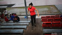 Seorang atlet memanfaatkan anak tangga tribun penonton sebagai tempat untuk latihan.