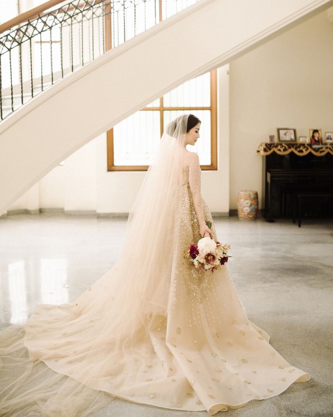 Saat upacara pemberkatan pernikahan di Surabaya, Silvia tampil sangat cantik dan elegan dengan gaun pengantin rancangan desainer lokal, Tinara Bridal. Gaunnya yang kayak detail ditambah dengan veil yang panjangnya menyapu lantai. Foto: Instagram @ silviasiantar