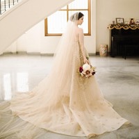 Saat upacara pemberkatan pernikahan di Surabaya, Silvia tampil sangat cantik dan elegan dengan gaun pengantin rancangan desainer lokal, Tinara Bridal. Gaunnya yang kayak detail ditambah dengan veil yang panjangnya menyapu lantai. Foto: Instagram @ silviasiantar