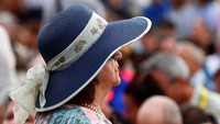 Salah seorang turis di Vatikan menggunakan topi berjenis floppy hat dengan aksen bunga saat berkeliling kota. Max Rossi/Reuters.