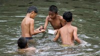 Sambil berenang, anak-anak itu pun mencari berbagai hal unik yang dapat dijadikan mainan dari dalam Sungai Ciliwung.