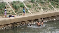 Air di Sungai Ciliwung, Jakarta, tampak surut. Anak-anak sekitar sungai itu pun memanfaatkannya menjadi tempat berenang, Kamis (20/9/2018).