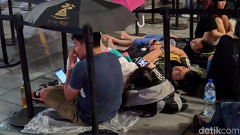 Sempat hujan deras tak berpengaruh bagi mereka. Payung jadi pelindung untuk mempertahankan posisinya demi iPhone baru. Foto: Adi Fida Rahman/detikinet