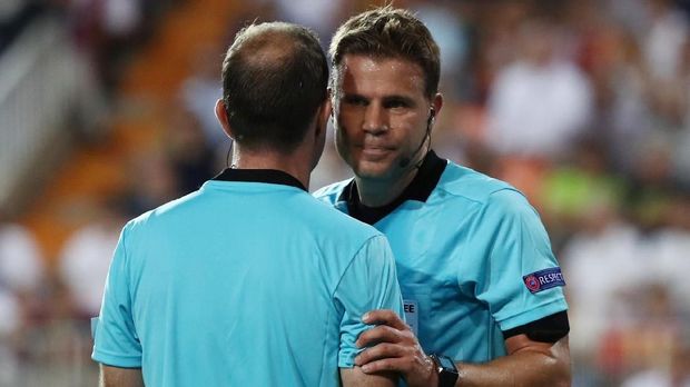 Wasit Felix Brych berkomunikasi dalam laga Liga Champions.