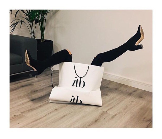 Wanita ini berhasil meniru pose keluar dari tas belanja ala Victoria Beckham. Fotonya terlihat lebih stylish dengan booties hitam. Foto: Instagram @sarah_erick