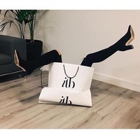 Wanita ini berhasil meniru pose keluar dari tas belanja ala Victoria Beckham. Fotonya terlihat lebih stylish dengan booties hitam. Foto: Instagram @sarah_erick