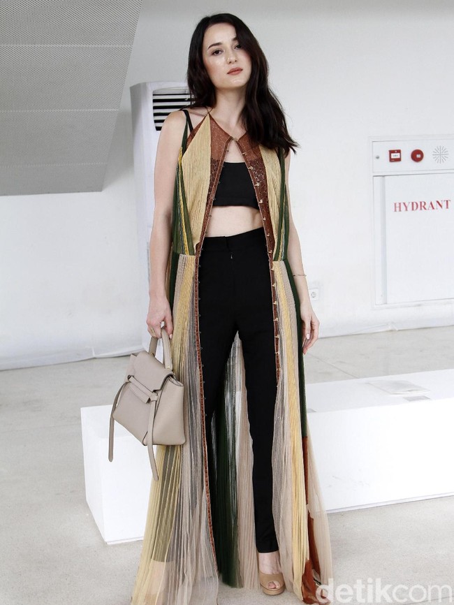 Julie Estelle tampil seksi dengan miniset dan legging hitam, serta vest panjang sebagai luaran. Peep toe heels jadi andalan untuk menopang kaki jenjangnya. (Foto: Mohammad Abduh/Wolipop)