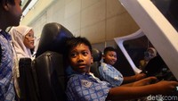 Anak-anak menjajal simulator pesawat terbang.