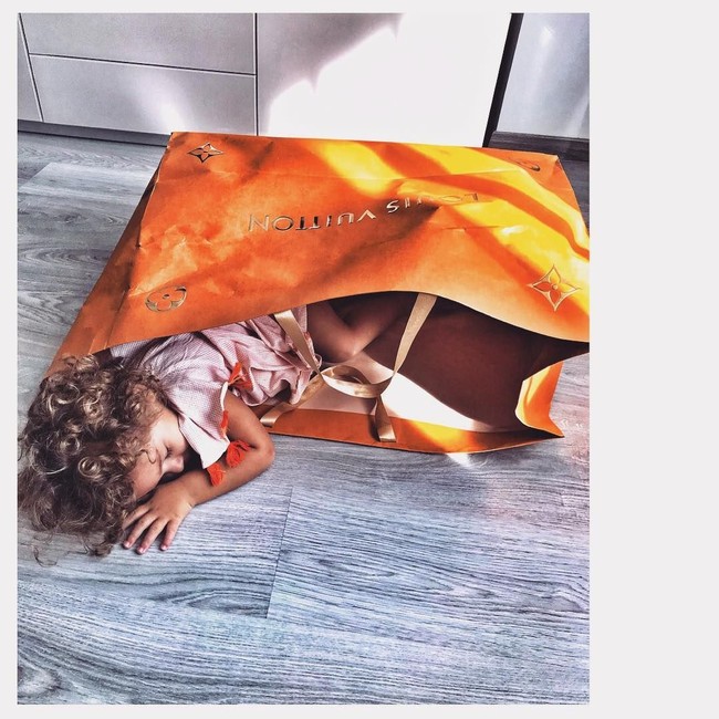 Anak ini tampak menggemaskan dan stylish di saat bersamaan saat berpose tidur di dalam tas belanja Louis Vuitton. Foto: Instagram @polishia