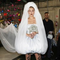 Gaunnya tampak unik dengan stocking putih berhias coretan hitam, bersama kerudung unik yang diselipkan ke bawah gaun dan mengalir di belakangnya. Foto: Dok. Getty Images