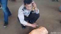 Pak polisi ini tengah memeragakan meminta bantuan medis. Biasa saja dong pak ekspresinya hehe. Foto: Widiya Wiyanti/detikHealth