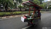 Seorang pedagang melintas diantara pengamanan KPU.